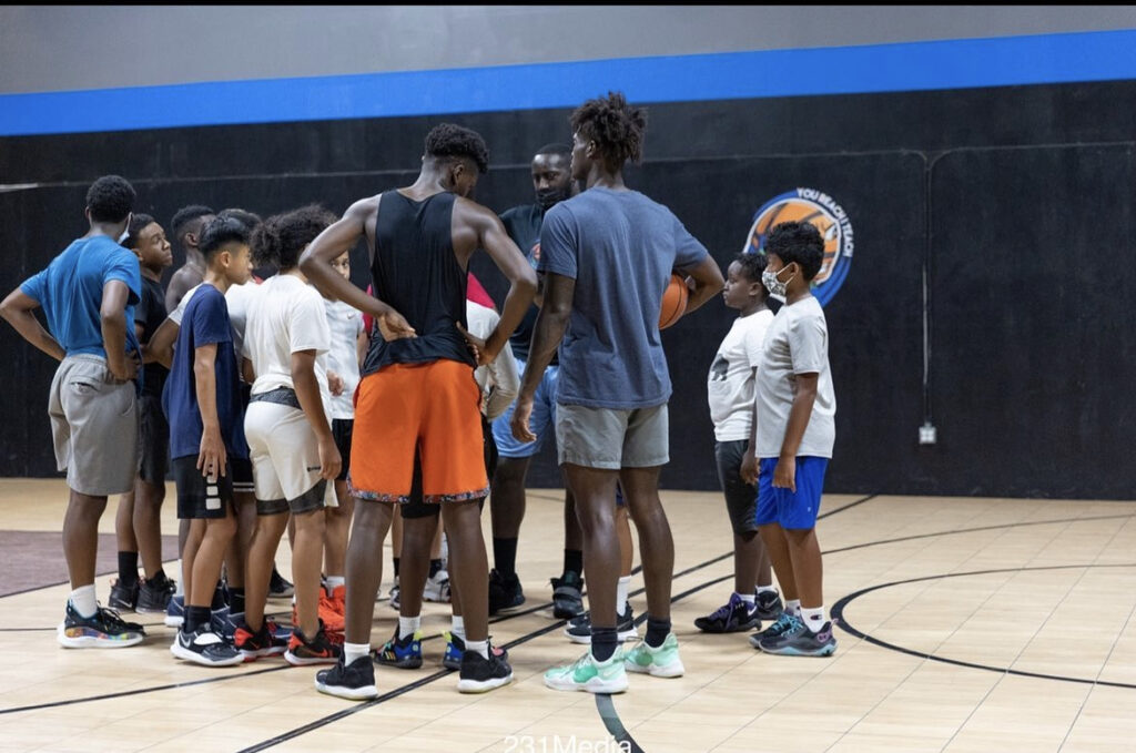 Players gathered in a huddle on the court during a training session.