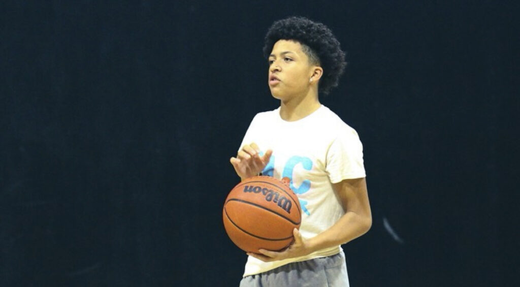Young player holding a basketball, ready to make a pass.