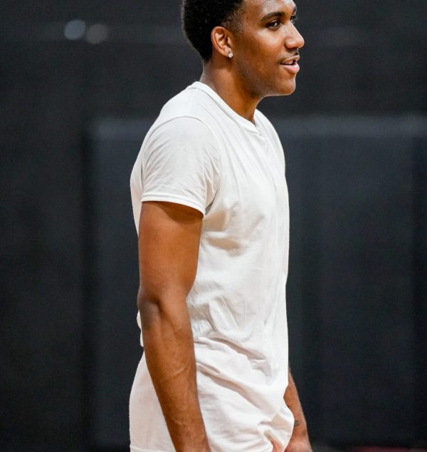 Basketball player standing on the court in a quiet moment.
