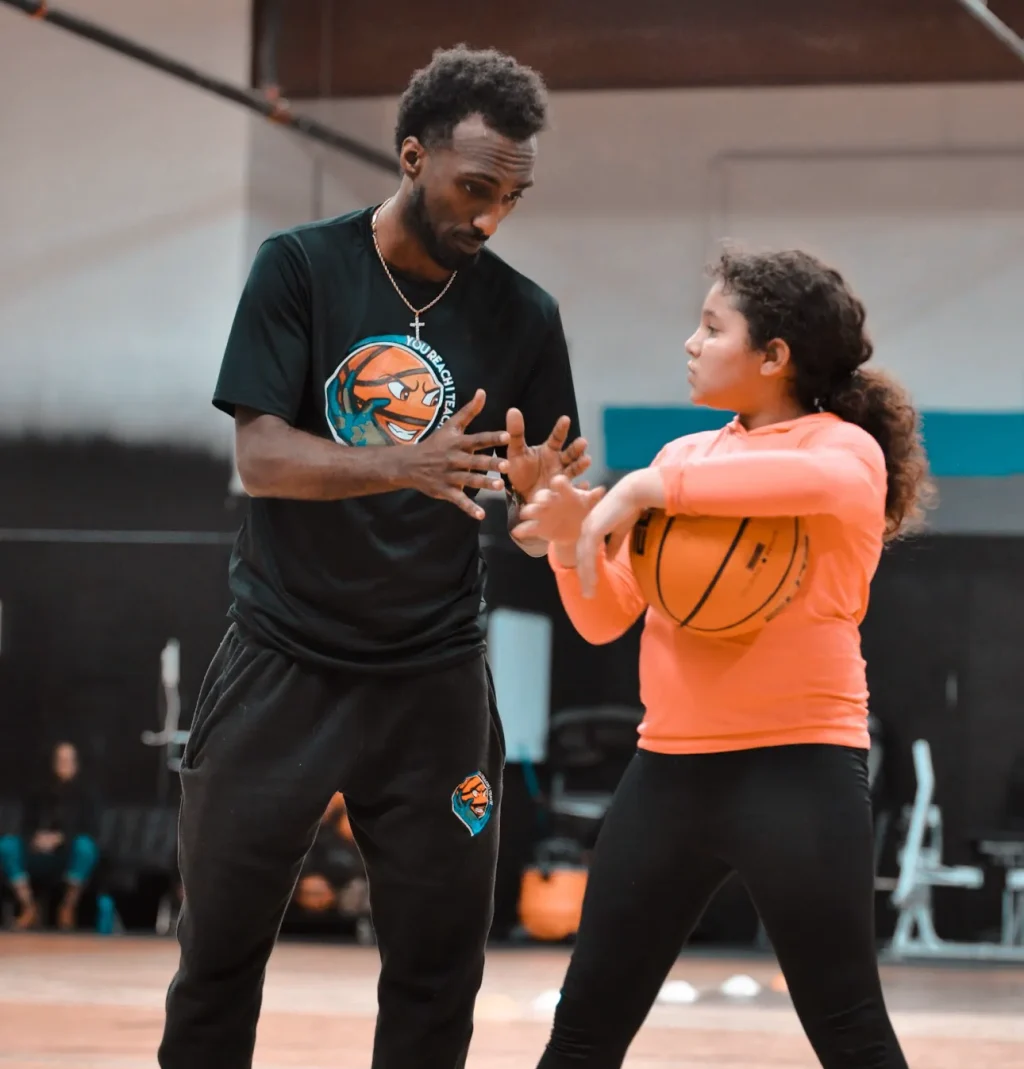 Coach demonstrating proper hand positioning to a young player.
